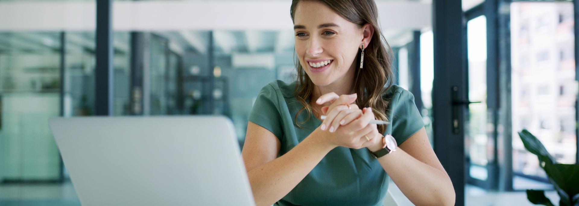 A woman looking at a laptop and smiling